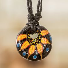 The grace of the Guatemalan nights is captured in a jolly design that pays honor to the region's natural richness and arts. Pedro Apop creates this pendant necklace from ceramic using a traditional process that allows him to craft the round piece that dangles from the adjustable cotton cord. As a touch of uniqueness, the artisan also hand-paints the pendant with a floral design, whose palette of yellow, orange, blue and black hues creates a cheerful vibe. In addition, a sliding knot makes it pos Ceramic Pendant Necklace, Ceramic Pendant, Sliding Knot, The Grace, Cotton Cord, Blue And Black, Yellow Orange, Long Necklace, Jewelry Inspiration