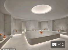 a large room with several sinks and lights on the walls, all in white marble