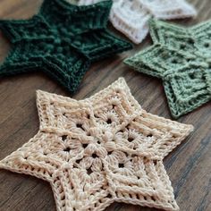 three crocheted stars on a wooden surface