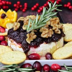 a platter with crackers, cranberry sauce and nuts