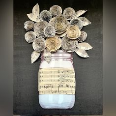 a jar filled with paper flowers on top of a table