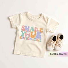 "Your toddler will look adorable in this \"SHAKE YOUR COTTON TAIL\"  Toddler short sleeve tee. This lightweight side-seamed shirt maximizes comfort all day long.  Shake Your Cotton Tail Toddler Shirt, Funny Easter Bunny Baby T-Shirt, Groovy Easter Bunny Retro, Christian Shirt Rabbit Tee Bunny Baby Gift 🌟100% Airlume combed and ringspun cotton (fiber content may vary for different colors) 🌟Light fabric (3.9 oz/yd² (132 g/m 🌟Retail fit RETURNS: All products are made-to-order and because of the nature of these items, all sales are final unless they arrive damaged or defective. CARE INSTRUCTIONS Machine wash: cold (max 30C or 90F); Non-chlorine: bleach as needed; Tumble dry: low heat; Iron, steam or dry: medium heat; Do not dryclean. PLEASE SEE THE SIZING CHARTS for the measurements, and pl Funny Print Short Sleeve Tops For Playtime, Short Sleeve Tops With Funny Print For Playtime, Playtime Tops With Funny Print And Short Sleeves, Funny Print Tops For Spring Playtime, White Tops With Funny Print For Playtime, Cotton Tops With Letter Print For Playtime, Cute Cotton T-shirt With Name Print, Unisex Cute T-shirt For Playtime, Family Matching Cotton Shirt For Playtime