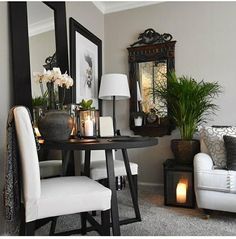 a living room filled with furniture and a mirror on the wall next to a table