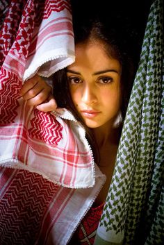 a woman peeking out from behind a blanket