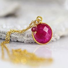 Back in stock! This striking Ruby necklace looks rich and exotic, and is perfect for adding colour to any outfit or occasion. Featuring a sparkling, round, cut and faceted ruby set in a bezel setting and paired with a dangling ruby gem. Available in various lengths. Rubies are the birthstone for July and the 40th wedding anniversary. Ruby jewelry makes a perfect romantic gift for a loved one, whether for a birthday, anniversary or Valentine's Day, as Rubies have always been associated with love Handmade Ruby Necklaces With Spiritual Style, Handmade Ruby Spiritual Necklaces, Handmade Spiritual Ruby Necklaces, Ruby Round Pendant Necklace, Red Faceted Pendant Necklaces, Gemstone Round Necklace Gift For Her, Red Faceted Pendant Necklace, Gemstone Necklace Gift For Her, Unique Faceted Necklaces