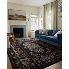 a living room with a blue couch and rug in front of a fire place on the wall