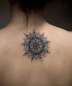 the back of a woman's neck with a tattoo on it