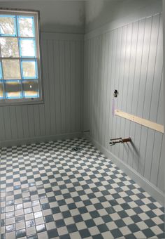 an empty room with blue and white tiles on the floor