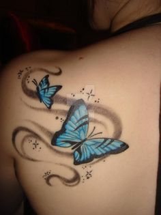 the back of a woman's shoulder with two blue butterflies on it