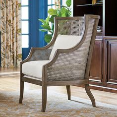 a chair sitting on top of a wooden floor next to a book shelf and window