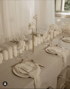 the table is set with white plates and silverware