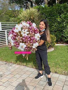 a woman holding a large bouquet of flowers in front of her face and smiling at the camera