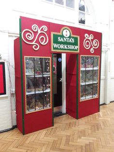 the santa's workshop store is decorated with red and green doors, which are open