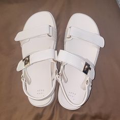 Brand New Never Worn! Size 9.5 White Flat Slingback Sandals With Buckle Closure, White Flat Sandals With Adjustable Strap, White Flat Heel Slingback Sandals Trendy Style, White Flat Everyday Sandals, White Flat Sandals For Everyday Wear, Trendy Cream Ankle Strap Sandals, White Flat Sandals For Everyday, White Sandals With Adjustable Strap For Spring, White Round Toe Sandals For Everyday