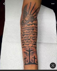 a person with a tattoo on their arm that has an image of a cross and dove