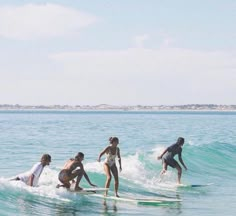 four people on surfboards in the ocean