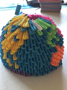 a multicolored object sitting on top of a table next to a pile of books