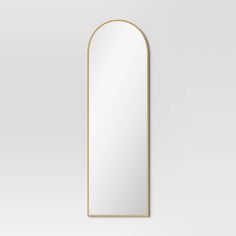 an arched mirror on a white wall