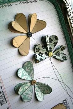 four paper flowers sitting on top of a notebook