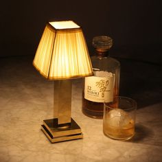 a table lamp next to a bottle of whiskey