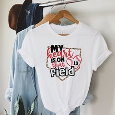 My Heart Is On That Field Custom Baseball Mom Shirt, Baseball Mom Shirt, Plus Size Baseball Mom, Baseball Mom T-Shirts, Baseball Grandma All of our adult t-shirts are Bella + Canvas 3001 Unisex shirts, unless otherwise noted on size charts (vnecks, tanks and youth/children's items are not the same material). They are a super soft fabric that will quickly become a go to in your wardrobe. Its lightweight and flexible material is perfect for casual wear or any activity. Please make sure to check ou White Sports Fan Shirt With Letter Print, Graphic Tee With Heat Transfer Vinyl For Sports Events, Graphic Tee T-shirt For Sports Events, White Tops With Heat Transfer Vinyl For College, White Tops With Heat Transfer Vinyl For Sports Season, Sporty Tops With Heat Transfer Vinyl For Fans, Casual T-shirt With Heat Transfer Vinyl For Sports Events, Team Spirit Shirt With Sublimation Print For Baseball Season, Sporty T-shirt With Heat Transfer Vinyl For College