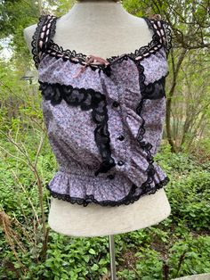 "We think someone had a blast making this cami/top for a special event.  It's done in a sweet lavender + pink floral, but then they added black lace for a bit of sauciness.  The front closes up with 5 buttons, and the pink ribbon that runs around the neckline cinches that area to your wishes.   Bust 42\" fully extended, but don't forget that it cinches Waist 26\"---no stretch here at all" Purple Whimsigoth, Lavender Floral, Lavender Pink, Floral Cami, Full Skirts, 1940s Dresses, 80s Dress, Satin Gown, Blue Satin