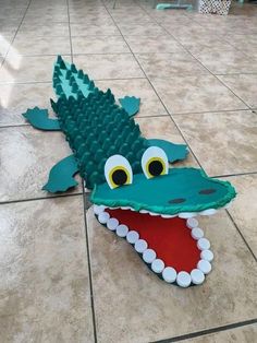 an alligator made out of legos laying on the floor with its mouth open and eyes wide open