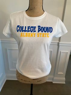 "Made to Order: TWOSDay T-Shirt  1) Choose your t-shirt size 2) Choose the color scheme for the word \"College Bound\" and \"Actual College\" that you want on the shirt 3) Choose the color of your shirt 4) Select type of shirt (Short Sleeve T-Shirt, Long Sleeve T-Shirt, Tank Top, Sweatshirt)" White Slogan T-shirt For College, Collegiate Cotton T-shirt With Slogan, Collegiate White T-shirt With Text Print, White Collegiate T-shirt With Text Print, White Cotton T-shirt For School Spirit, Basic College T-shirt With Screen Print, White School Spirit T-shirt With Text Print, White T-shirt With School Spirit Text Print, White T-shirt With Text Print For School Spirit