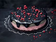 a black and pink cake with sprinkles on it