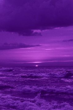 the sun is setting over the ocean with purple hues