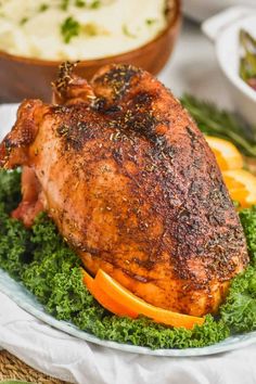 a whole chicken on a plate with oranges and greens