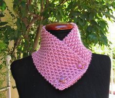 a pink crocheted cowl on a black mannequin in front of a tree