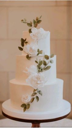 a wedding cake with white flowers and greenery