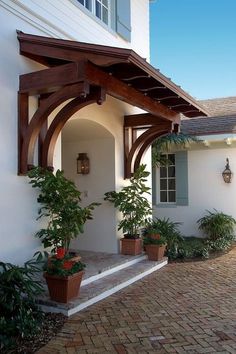 an outside view of a house with potted plants