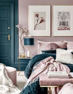 a bedroom with pink and blue walls, pictures on the wall and bed in it