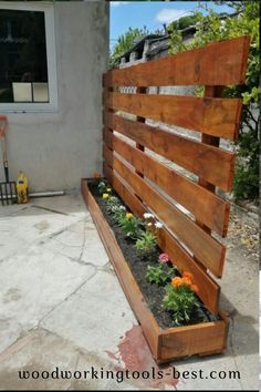 a wooden bench sitting on top of a patio next to a flower potted planter