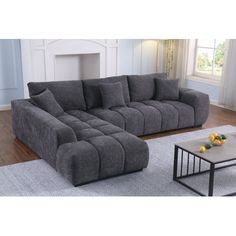 a large gray couch sitting on top of a wooden floor next to a coffee table