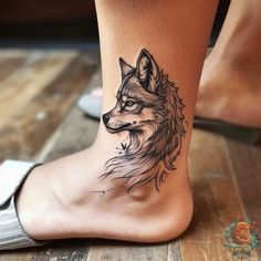 a woman's foot with a tattoo of a wolf on the side of her leg