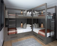 two bunk beds in a room with wood flooring and white pillows on top of them