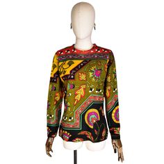 OlIVIER DE VERLON sweater. Vintage from the 1970s. wool fabric. long sleeve pullover. African-inspired pattern. Geometric pattern. Hot colors: green, red, yellow, and black. Blouse/shirt without pockets or buttons. Made in France. Size on label: 2 Approximate size: L Measurements: Shoulder to shoulder: 40 cm (15.5 inches) Bust: 96 cm (38.0 inches) in circumference (48 cm (19.0 inches) when measured in plane) Waist: 84 cm (33.0 inches) circumference (42 cm (16.5 inches) when measured in plane) Le Retro Long Sleeve Sweater With Graphic Print, Multicolor Long Sleeve Sweater With Geometric Pattern, Multicolor Geometric Pattern Long Sleeve Sweater, Vintage Multicolor Sweater With Graphic Print, Multicolor Vintage Sweater With Graphic Print, Vintage Multicolor Graphic Print Sweater, Retro Tops With Colorful Pattern For Fall, Retro Colorful Patterned Tops For Fall, Green Jacquard Knit Long Sleeve Top