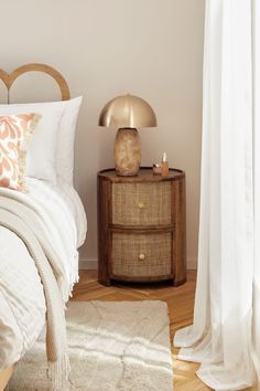 a bedroom with a bed, nightstand and white curtains