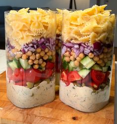 two jars filled with food sitting on top of a wooden table