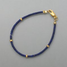 This lapis lazuli bracelet has a classic design throughout. Small rolls of lapis lazuli line up and are interrupted at regular intervals by similarly shaped gold-plated silver parts. The intense and dull blue of the lapis lazuli and the warm color of the gold combine to form a wonderfully uncomplicated and stylish bracelet. Here you will find the matching necklace or matching earrings Dimensions: Diameter of the rollers: 2 mm, length: 19 cm Gold Bracelets With Lapis Lazuli And Natural Stones, Hand-strung Gold Lapis Lazuli Bracelets, Gold Beaded Lapis Lazuli Bracelets, Dull Blue, Lapis Lazuli Bracelet, Stylish Bracelet, Matching Necklaces, Ear Jewelry, Gold Plated Silver