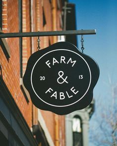 a sign hanging from the side of a building that says farm and table on it