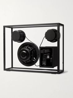 an electronic device with two speakers attached to it's back side, in a glass case