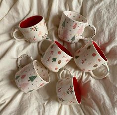 six coffee cups sitting on top of a bed