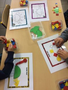 children playing with construction paper at a table