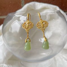 ⭐️ Introducing our Chinese vintage style dangles that the dangly part is made in synthetic jade that's in a light green color and the upper part is in a hollowed flower shape. ⭐️ The dangles showcase intricately designed Chinese elements, adding a cute and elegant touch to your look. ⭐️ Crafted with hypoallergenic materials, these earrings offer a comfortable and safe wearing experience.  ⭐️ The lightweight design makes them perfect for everyday wear or as an exquisite accessory for formal events. ⭐️ Ideal for various occasions, including weddings, parties, or adding a touch of elegance to your daily outfits. ⭐️ It also goes very well with Chinese Qipao dress or Hanfu. ✈️ Handling & Shipping usually takes about 10 days in total, so please consider the processing time if it's a time sensiti Jade Dangle Earrings For Pierced Ears, Jade Drop Earrings With Ear Wire, Pierced Jade Dangle Earrings, Yellow Gold Jade Earrings, Gold Jade Dangle Jewelry, Gold Jade Earrings, Gold Jade Earrings With Ear Wire, Teardrop Jade Earrings, Jade Dangle Earrings