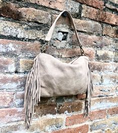 Beige suede fringed bag. Cross body hippy bag in beige suede leather with fringes. Beige boho bag . Natural genuine suede leather. Medium sized messenger bag. Large enough to fit your purse, keys, cellular and small cosmetics bag. Blue hippy bag with fringes. 2 straps, one shorter to wear the bag on the shoulder and a longer one to wear it crossbody. The inside of the bag is lined in a strong nylon fabric with a zipper pocket inside .   This suede bag is closed by a  zipper on its upper part  an Beige Tassel Hobo Tote Bag, Beige Tote Hobo Bag With Tassels, Beige Tassel Shoulder Bag For Everyday, Trendy Beige Shoulder Bag With Fringe, Beige Fringed Hobo Bag For Daily Use, Beige Fringe Hobo Bag For Daily Use, Fall Suede Shoulder Bag With Adjustable Strap, Beige Fringe Shoulder Bag For Daily Use, Chic Beige Fringe Bag