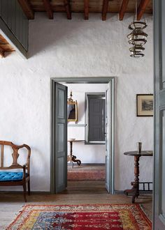 an open door leading into a room with a rug on the floor and two chairs